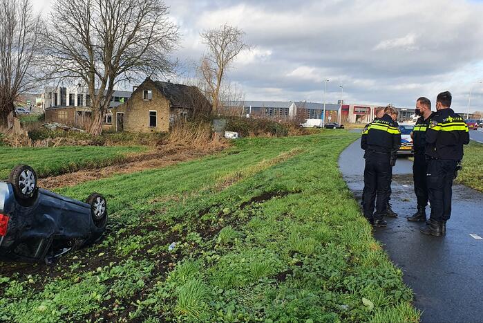 Personenauto raakt van de weg en belandt op zijn dak