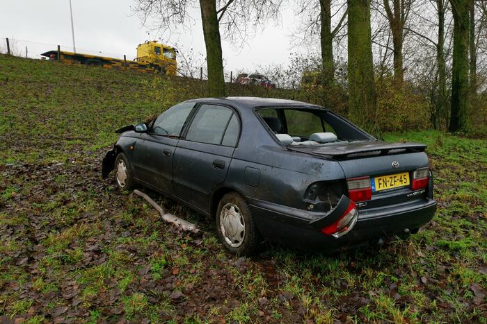 Auto belandt onderaan talud