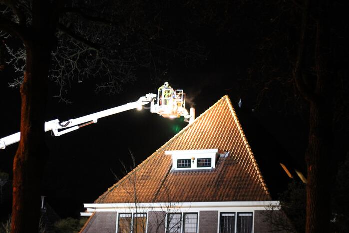 Brandweer blust brand in schoorsteen