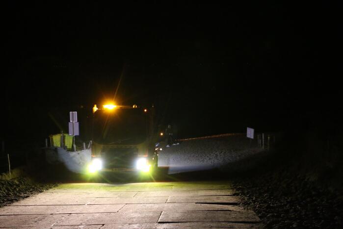 Automobilist rijdt auto vast op strand