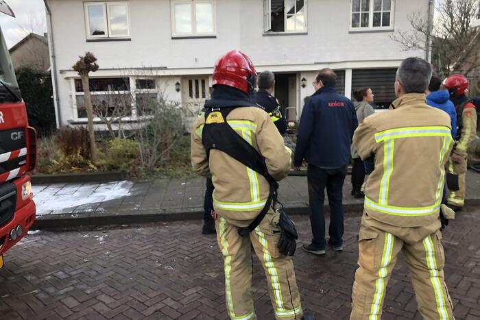 Zwarte rookwolken uit woning