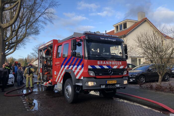 Zwarte rookwolken uit woning