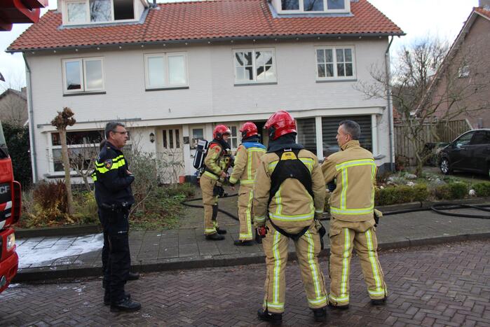 Zwarte rookwolken uit woning