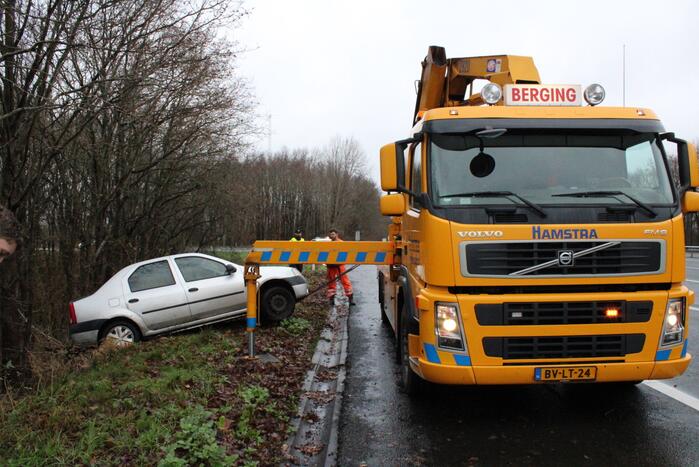 Auto glijdt greppel in bij afrit snelweg