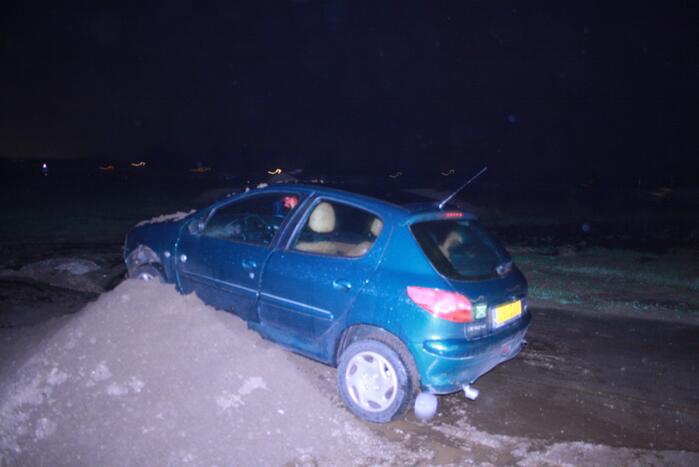 Auto schiet door tegen zandbult
