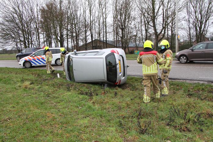 Auto belandt op zijn kant in berm