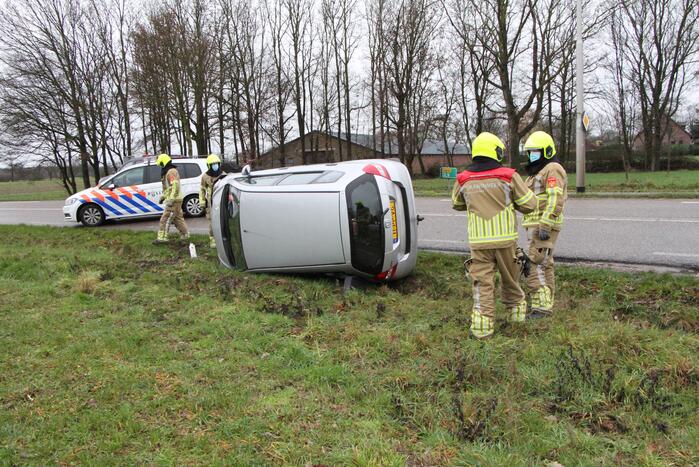 Auto belandt op zijn kant in berm
