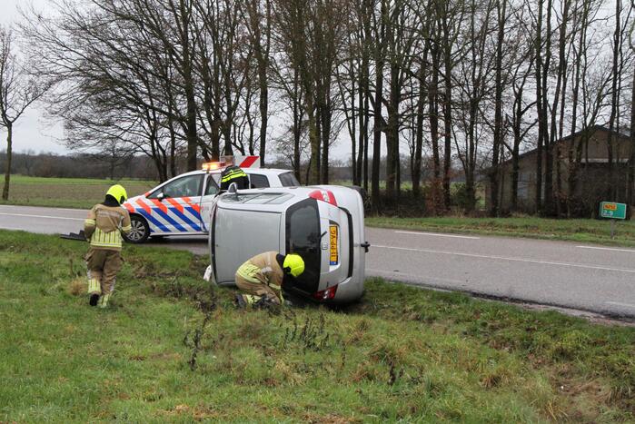 Auto belandt op zijn kant in berm