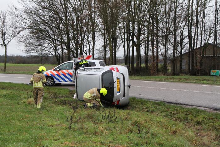 Auto belandt op zijn kant in berm