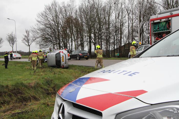 Auto belandt op zijn kant in berm