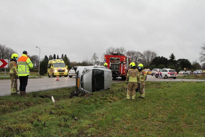 Auto belandt op zijn kant in berm