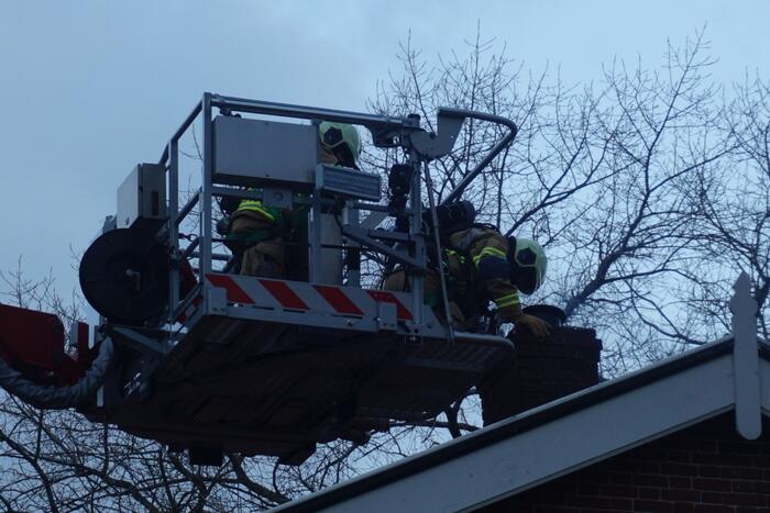 Brandweer veegt schoorsteen na brand