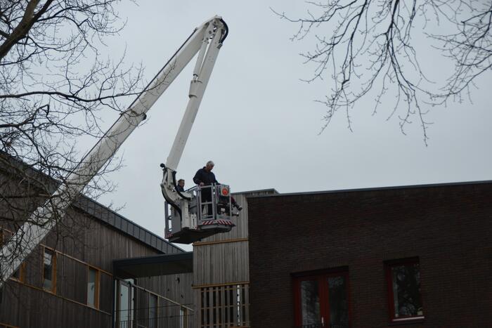 Zandzakken op dak pand door storm
