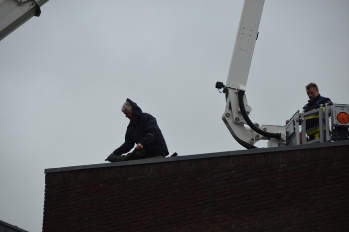 Zandzakken op dak pand door storm