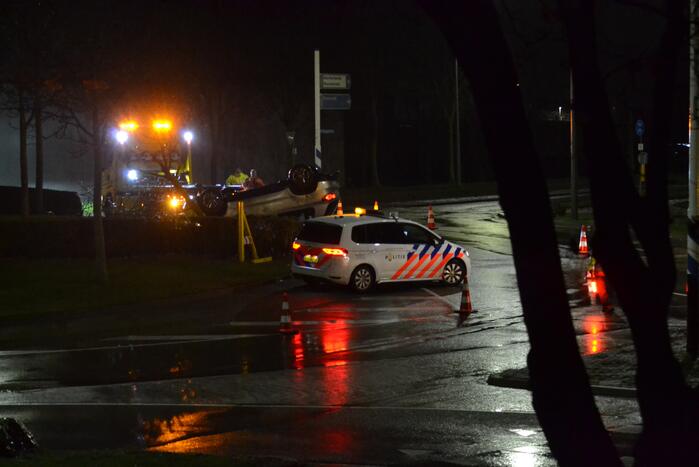 Auto belandt op de kop op rotonde