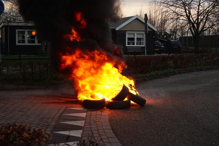 Stapel autobanden in brand gestoken