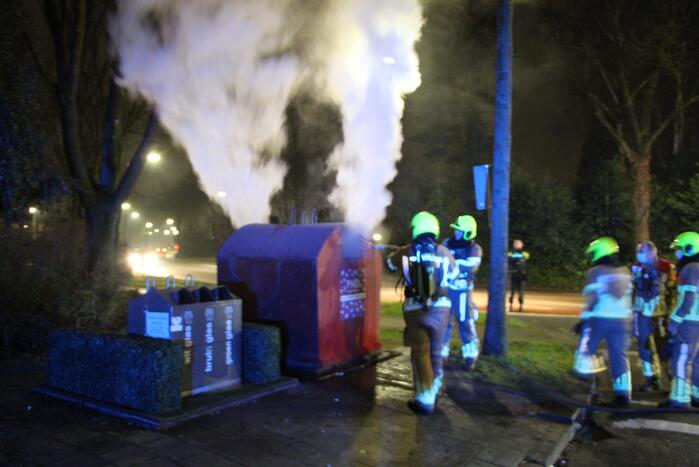 Brandweer blust brandende plasticcontainer