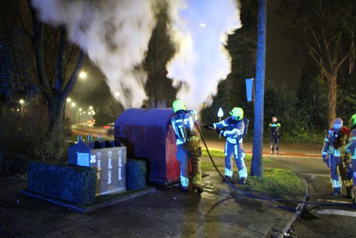 Brandweer blust brandende plasticcontainer