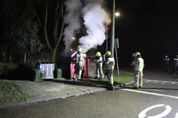 Brandweer blust brandende plasticcontainer