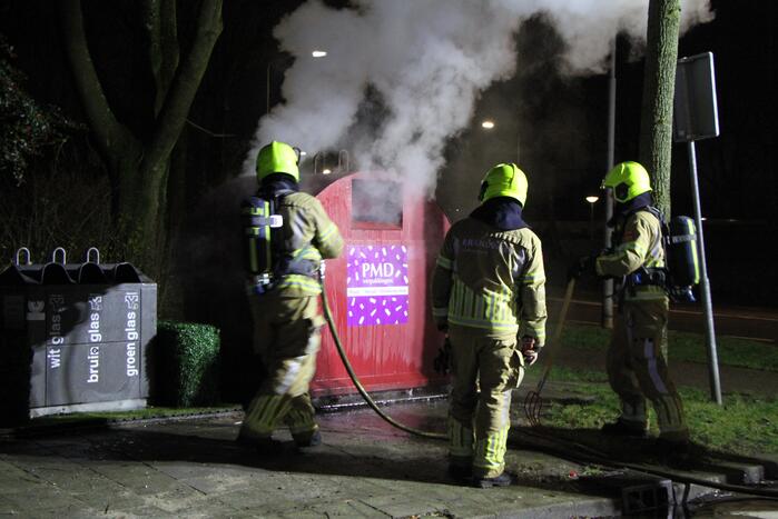 Brandweer blust brandende plasticcontainer
