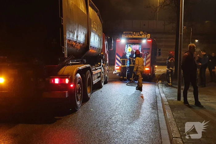 Brandweer blust brandend afval