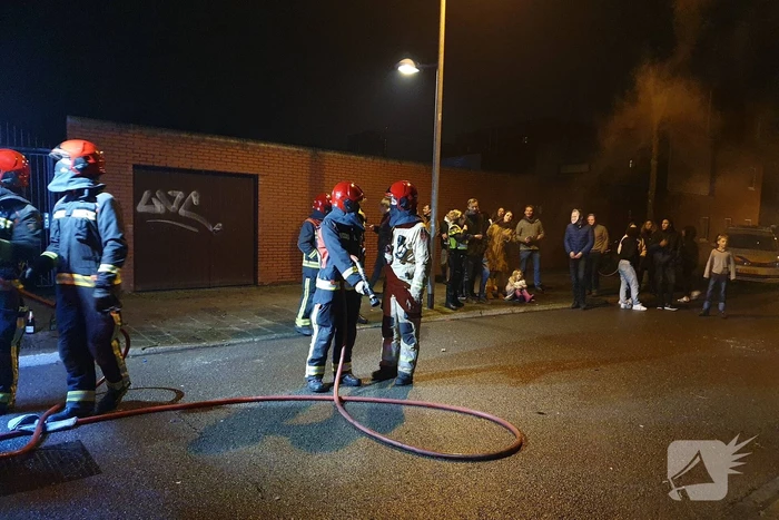 Brandweer blust brandend afval