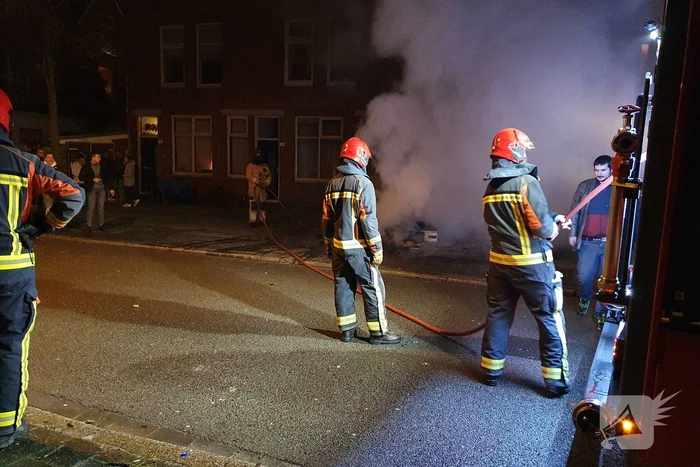 Brandweer blust brandend afval