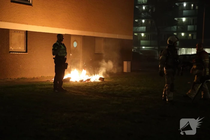 Hout en afval in brand tegen gevel