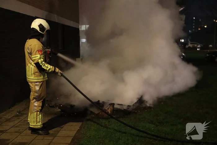 Hout en afval in brand tegen gevel
