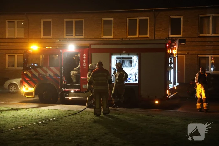 Hout en afval in brand tegen gevel