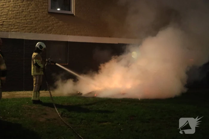 Hout en afval in brand tegen gevel