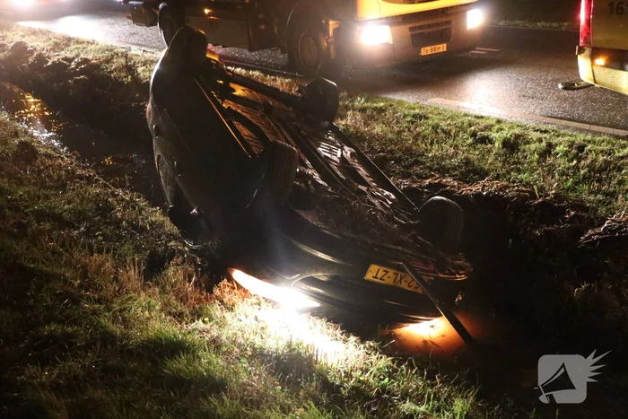 Auto belandt op dak in sloot