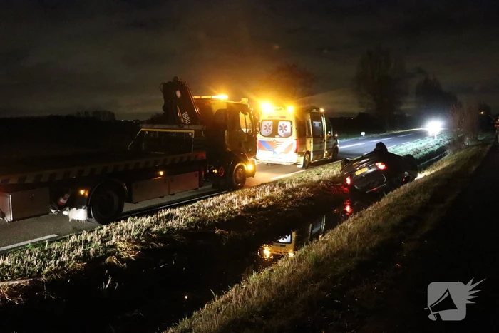 Auto belandt op dak in sloot
