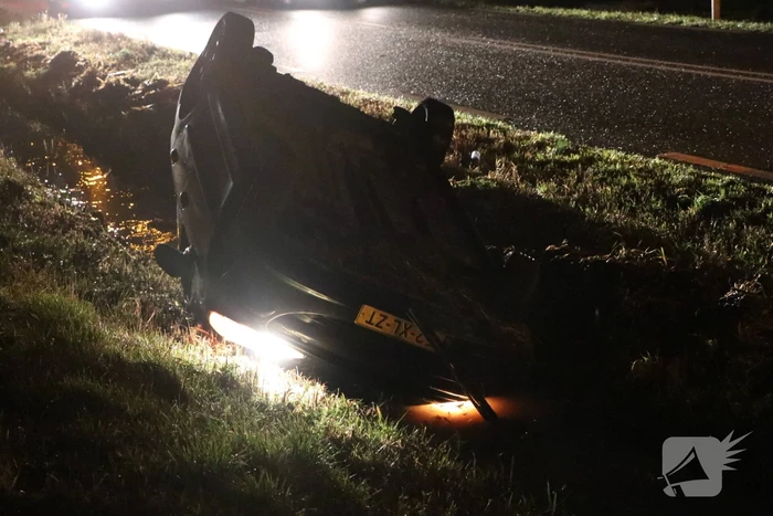 Auto belandt op dak in sloot