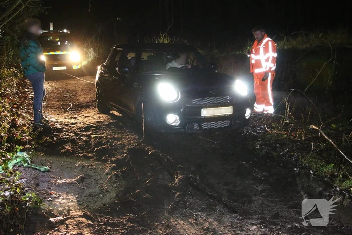 Auto rijdt zich vast in de modder