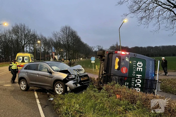 Bestelbus op zijn kant bij aanrijding