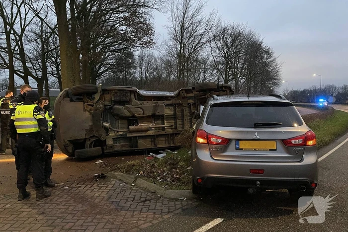Bestelbus op zijn kant bij aanrijding