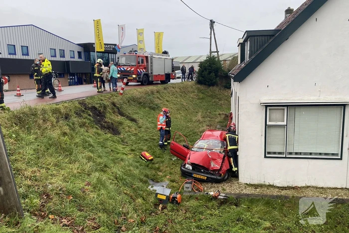 Auto rijdt van dijk en knalt tegen woning