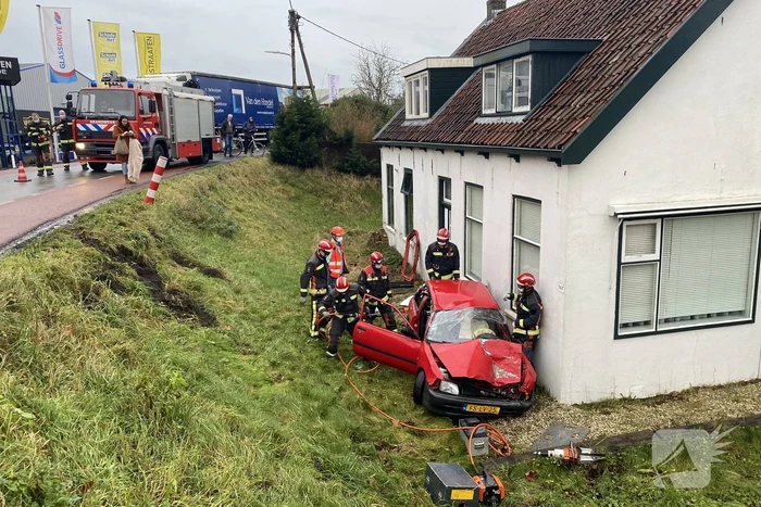 Auto rijdt van dijk en knalt tegen woning