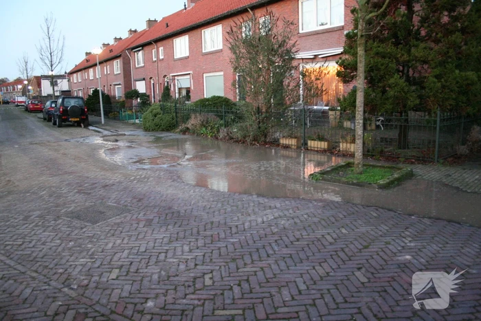 Straat onder water door gesprongen waterleiding