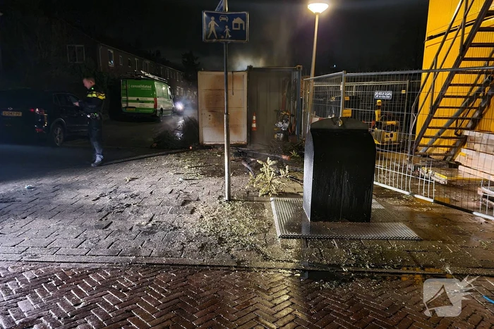 Kerstbomen tegen bouwcontainer in brand gestoken