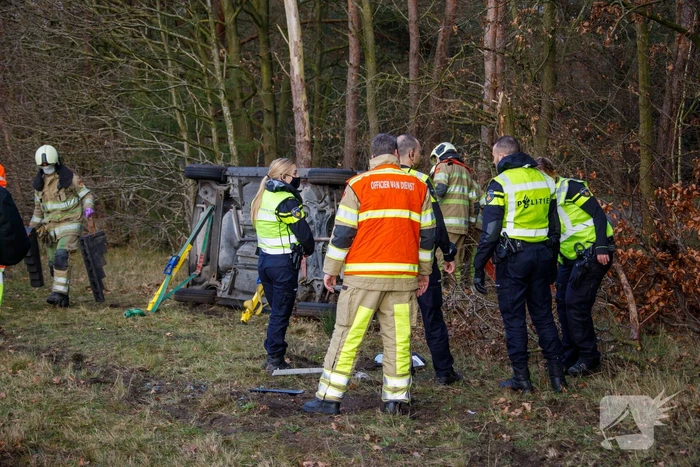 Auto vliegt uit de bocht en belandt op zijn kant