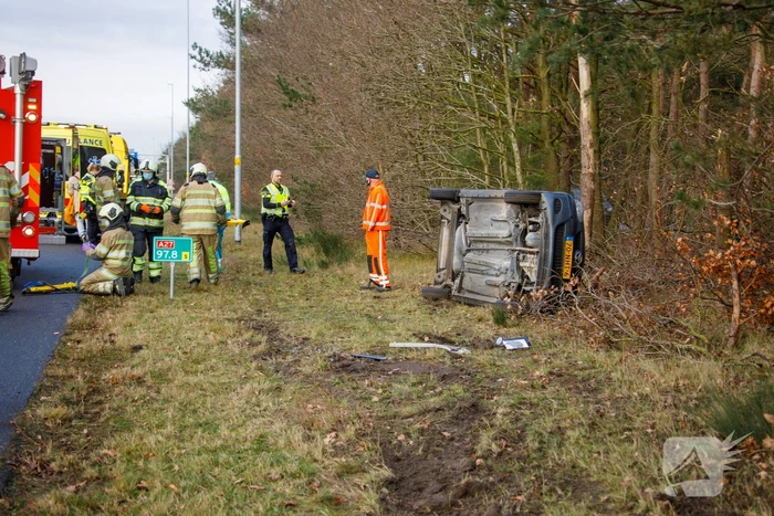 Auto vliegt uit de bocht en belandt op zijn kant