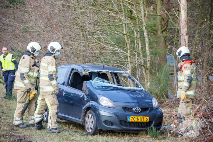 Auto vliegt uit de bocht en belandt op zijn kant