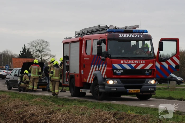 Rook onder motorkap van rijdende auto