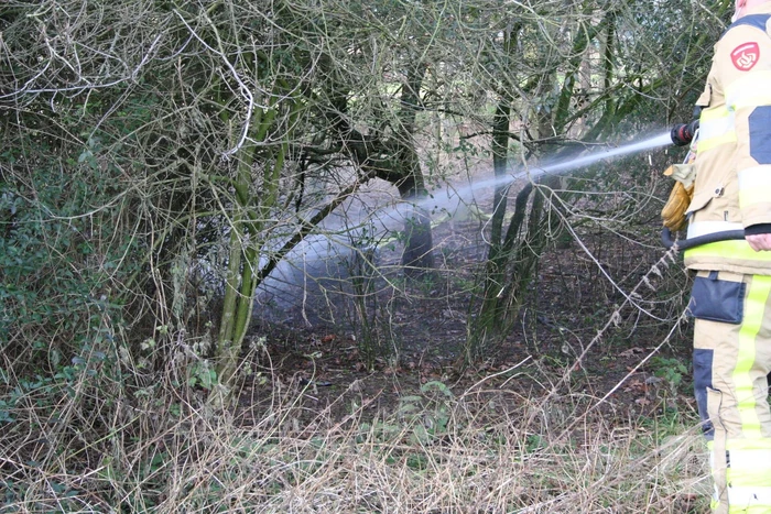 Brandweer blust autoband in bos