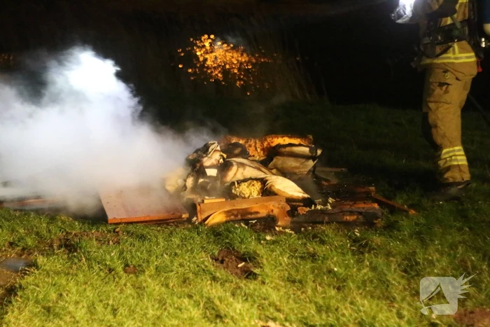 Brandweer blust brandende matras en pallets