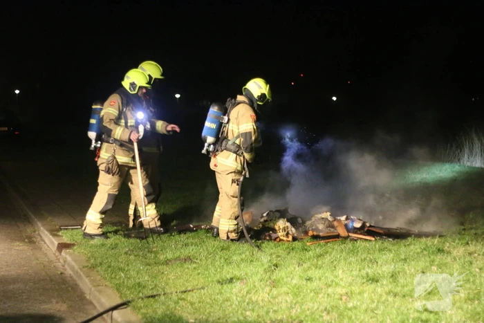 Brandweer blust brandende matras en pallets
