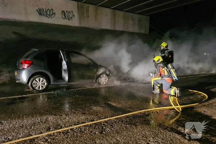 Auto vat vlam onder viaduct snelweg