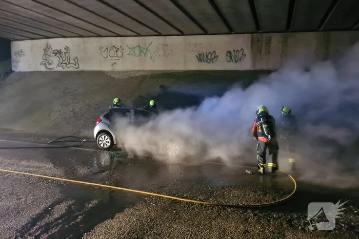 Auto vat vlam onder viaduct snelweg